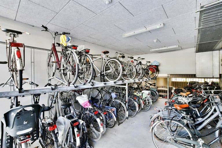 vélos stationnés dans un abri vélos en ouvrage, sur des racks double étage